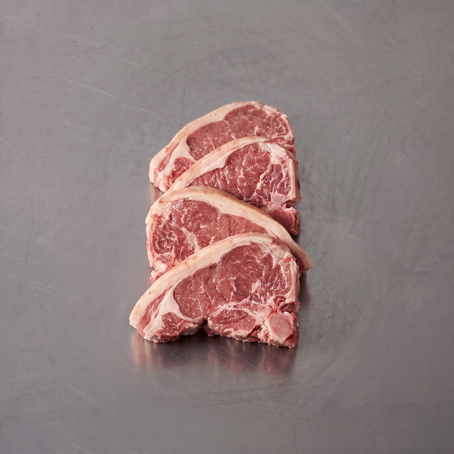 Grass Fed Lamb Loin Chops ~500g on stainless steel butcher's bench