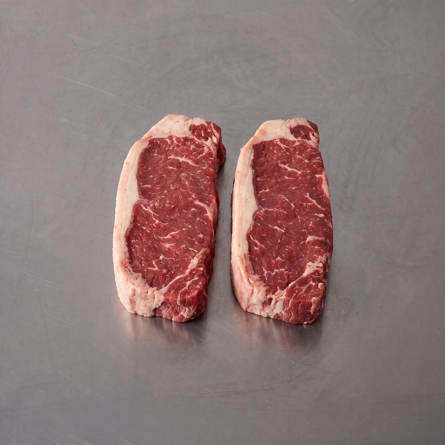 Grass Fed NY Sirloin ~500g on stainless steel butcher's bench