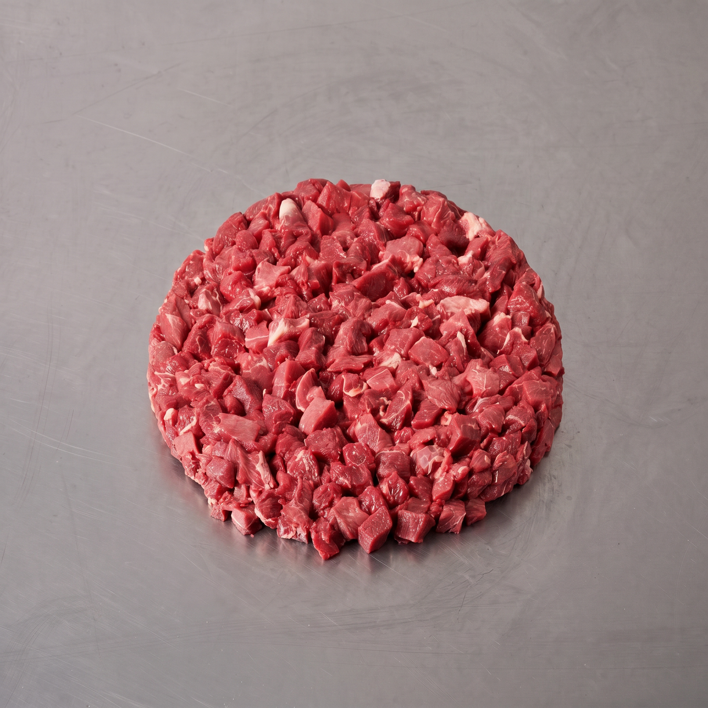 Grass Fed Diced Beef ~500g on stainless steel butcher's bench