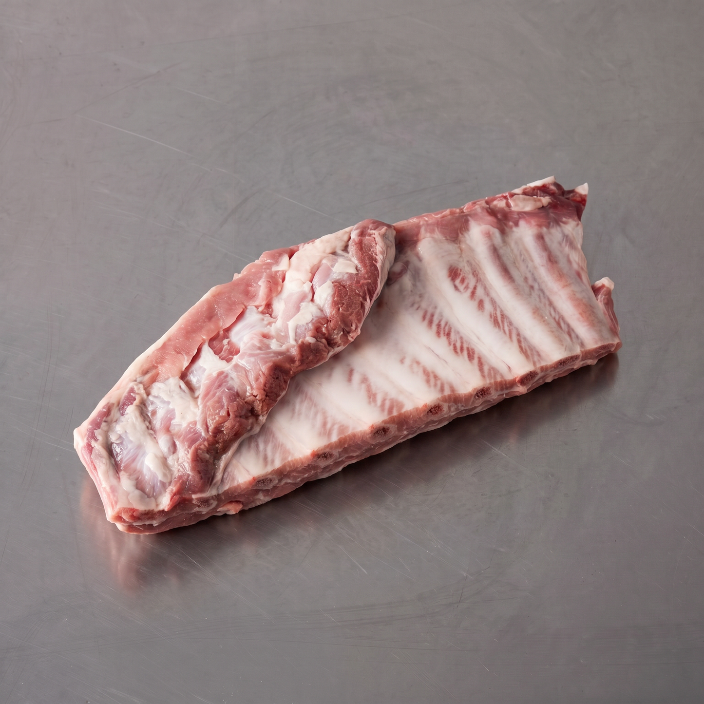 Free Range Pork Ribs ~1kg on stainless steel butcher's bench