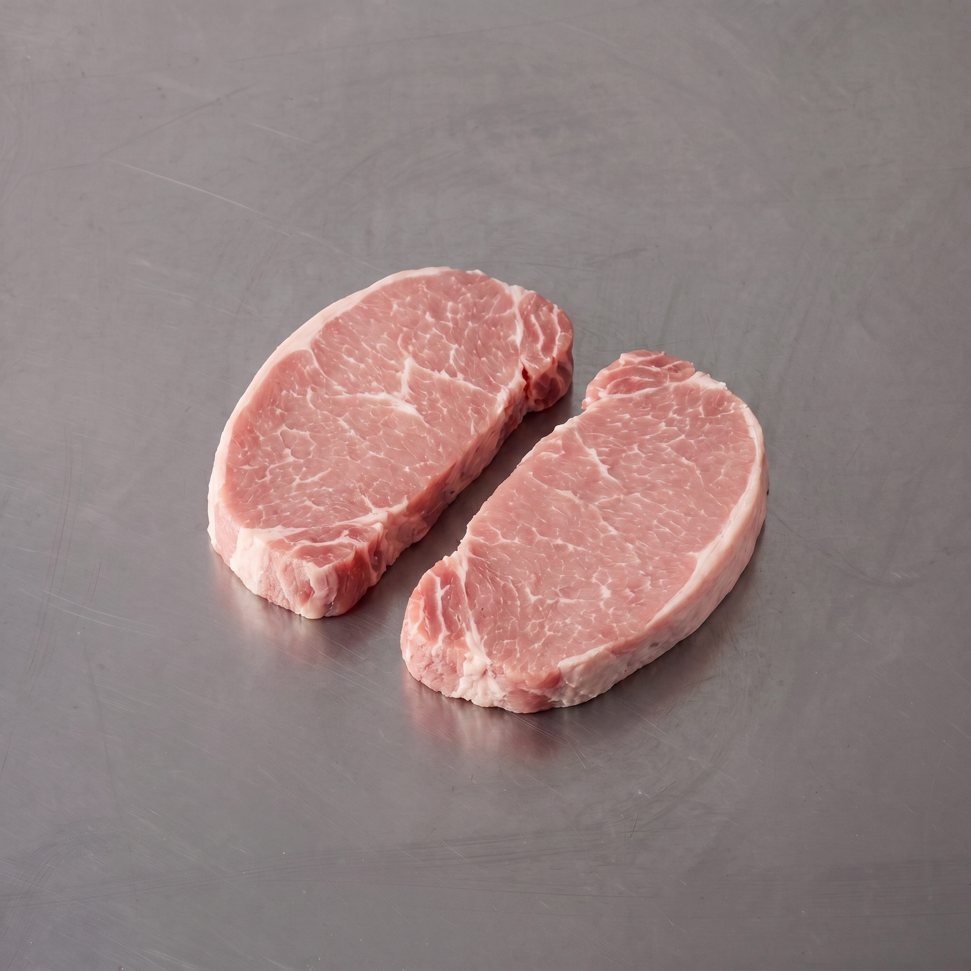 Free Range Pork Scotch Fillet ~500g on stainless steel butcher's bench